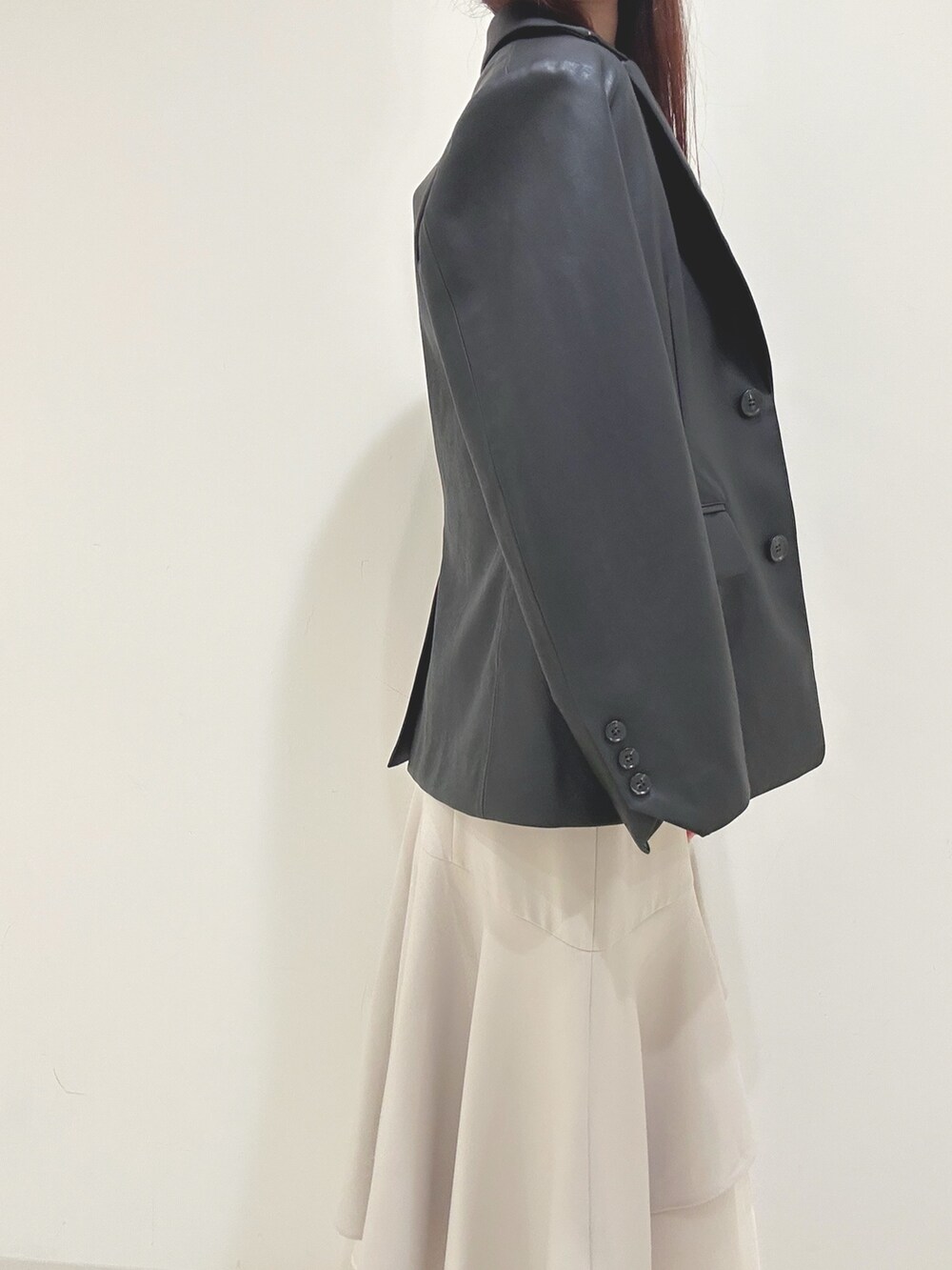 ベージュ系のスカート、グレー系のニット/セーター、ブラック系のハンドバッグを着用したレディースの秋コーディネートの6枚目の写真