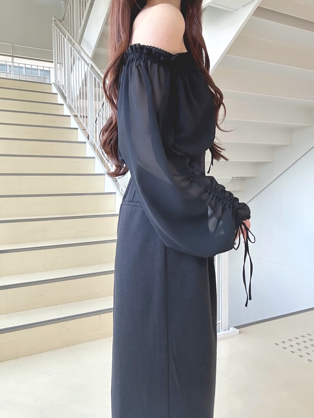 ブラック系のワンピース、ブラック系のショルダーバッグ、ブラック系のパンプスを着用したレディースの秋コーディネートの6枚目の写真