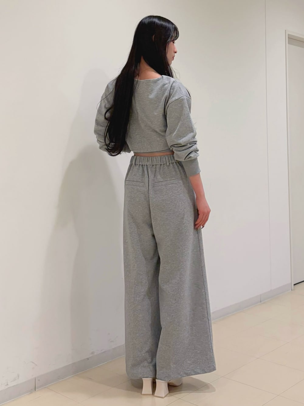 グレー系のその他パンツ、グレー系のTシャツ/カットソー、ホワイト系のパンプスを着用したレディースの冬コーディネートの3枚目の写真