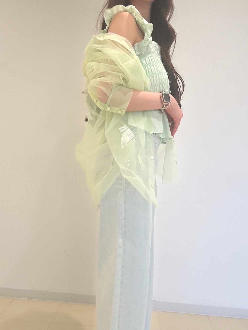 ブルー系のデニムパンツ、グリーン系のシャツ/ブラウス、ホワイト系のショルダーバッグを着用したレディースの春コーディネートの6枚目の写真