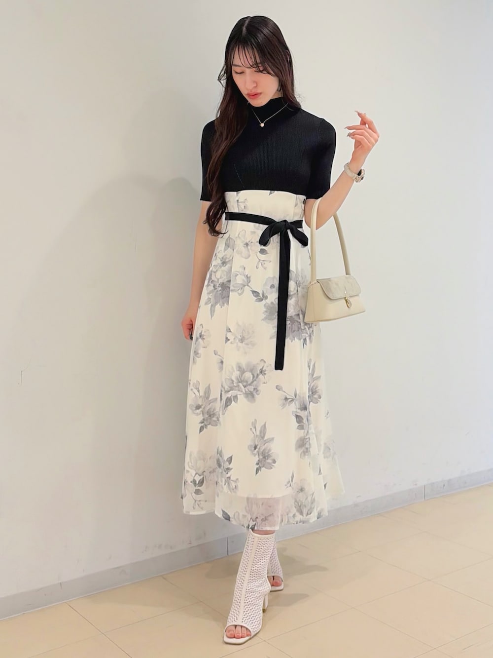 ブラック系のワンピース、パープル系のトレンチコート、ホワイト系のハンドバッグを着用したレディースの春コーディネートの3枚目の写真