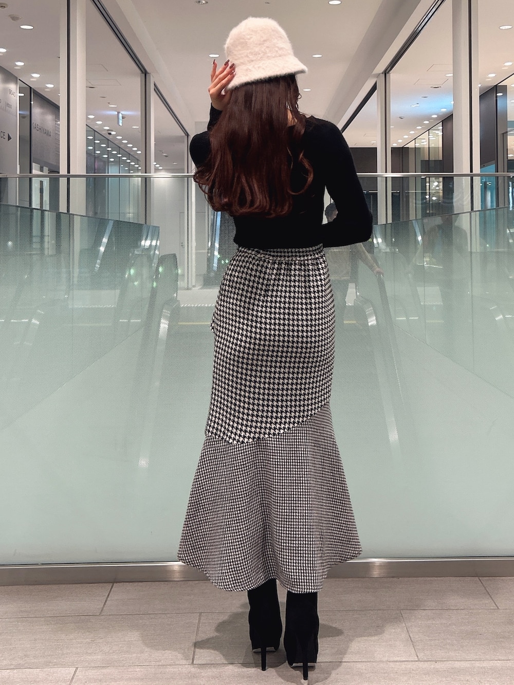 ブラック系のニット/セーター、ブラック系のブーツ、その他のスカートを着用したレディースの冬コーディネートの4枚目の写真