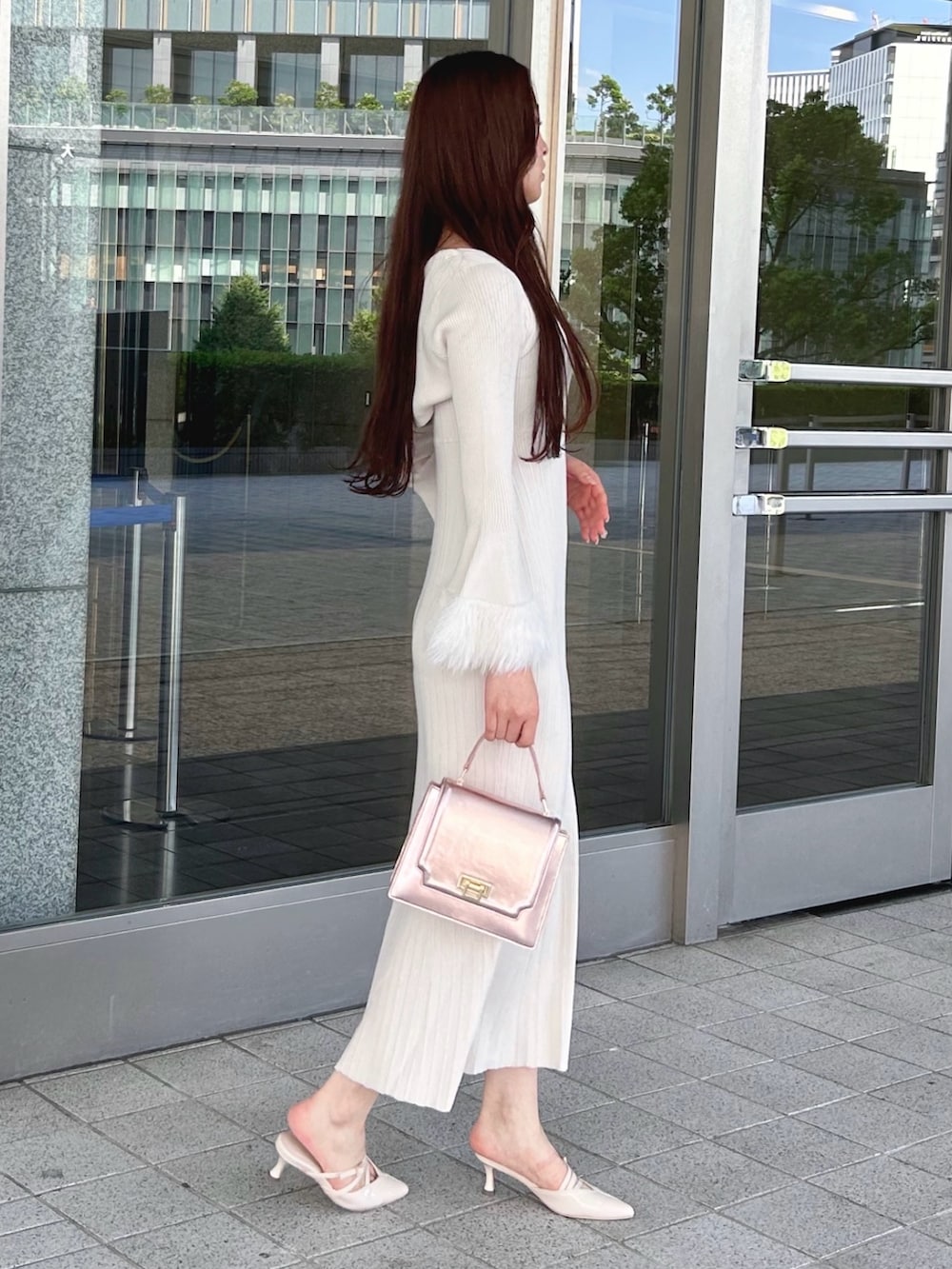 ホワイト系のワンピース、ピンク系のハンドバッグ、ベージュ系のパンプスを着用したレディースの秋コーディネートの3枚目の写真