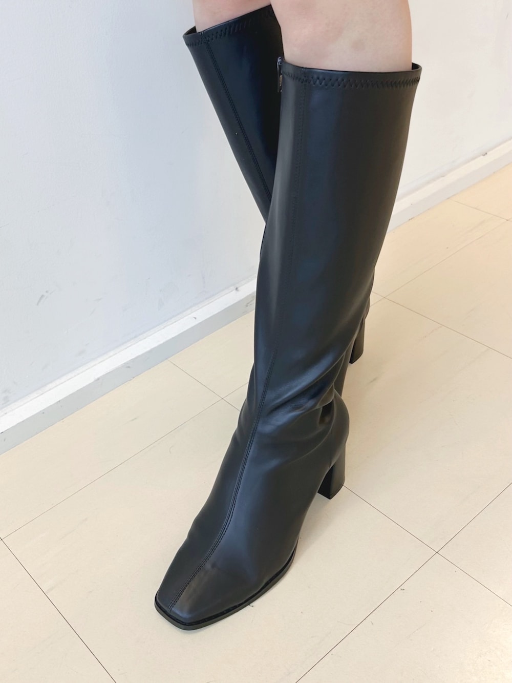 ブラック系のワンピース、ブラック系のキャミソール、ホワイト系のカーディガン/ボレロを着用したレディースの冬コーディネートの6枚目の写真