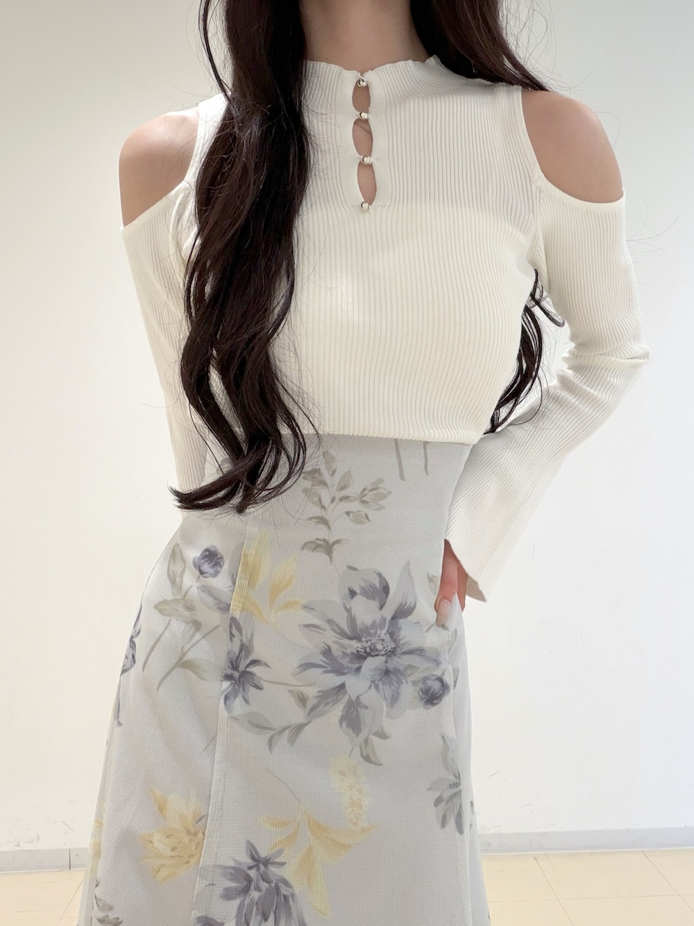 ホワイト系のニット/セーター、ブラウン系のハンドバッグ、グリーン系のスカートを着用したレディースの冬コーディネートの4枚目の写真