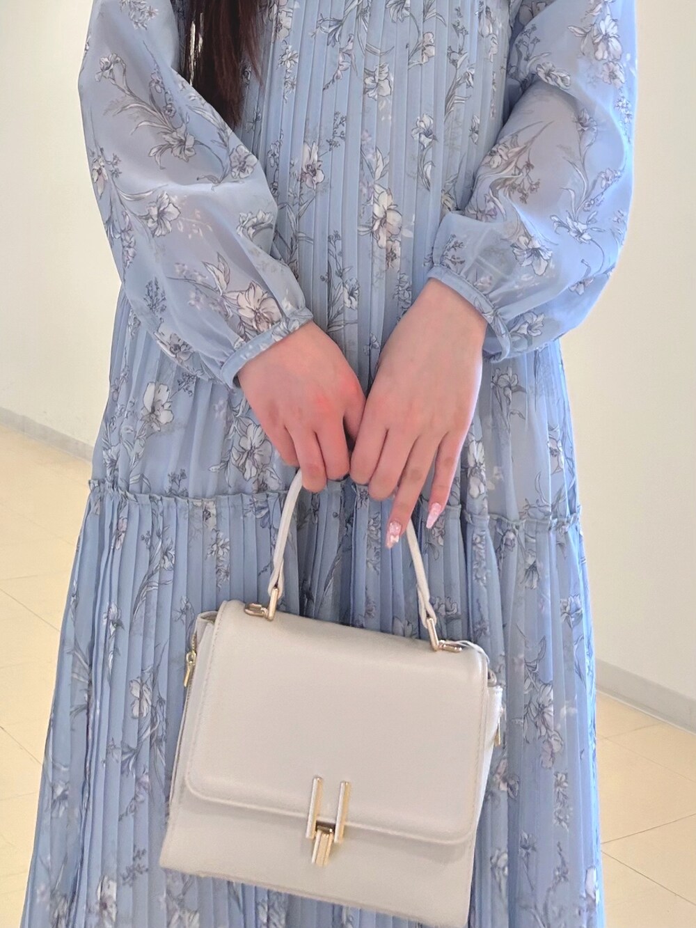 ブルー系のワンピース、ホワイト系のハンドバッグ、ホワイト系のパンプスを着用したレディースの春コーディネートの5枚目の写真