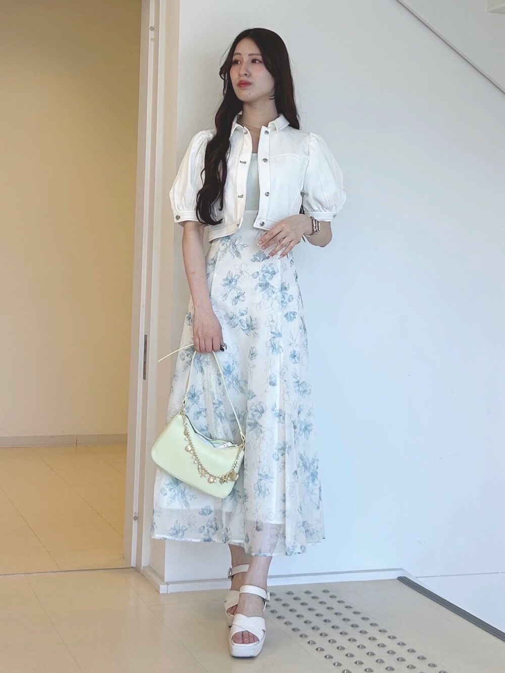 グリーン系のワンピース、グリーン系のハンドバッグ、ホワイト系のサンダルを着用したレディースの夏コーディネートの3枚目の写真