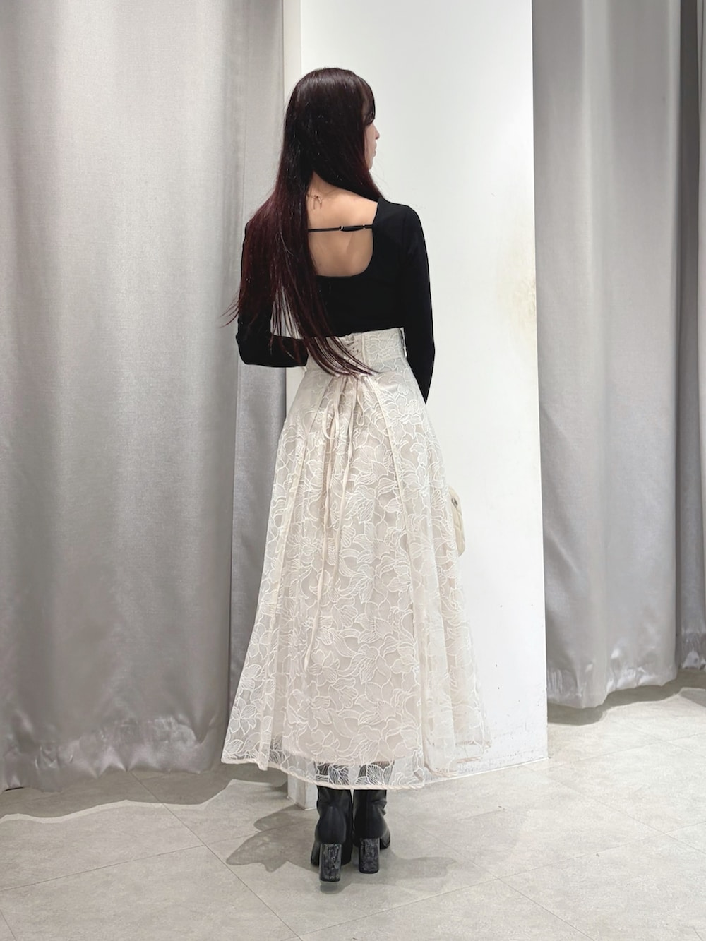 ホワイト系のスカート、ブラック系のブルゾン、ブラック系のTシャツ/カットソーを着用したレディースの秋コーディネートの4枚目の写真