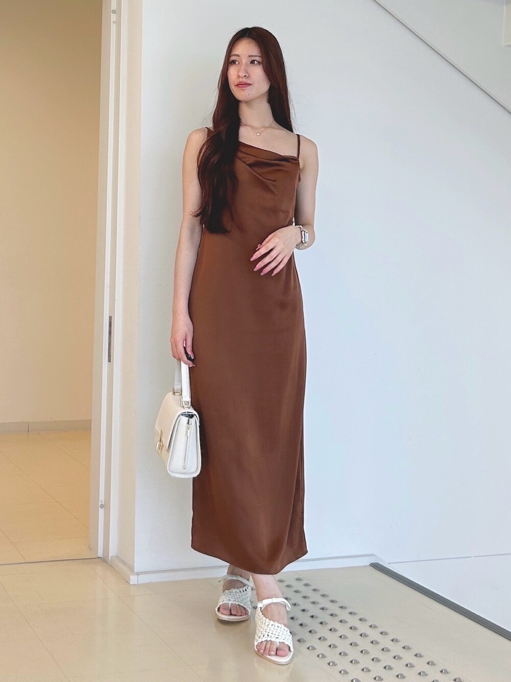 ブラウン系のワンピース、ホワイト系のハンドバッグ、ホワイト系のチューブトップを着用したレディースの夏コーディネートの3枚目の写真