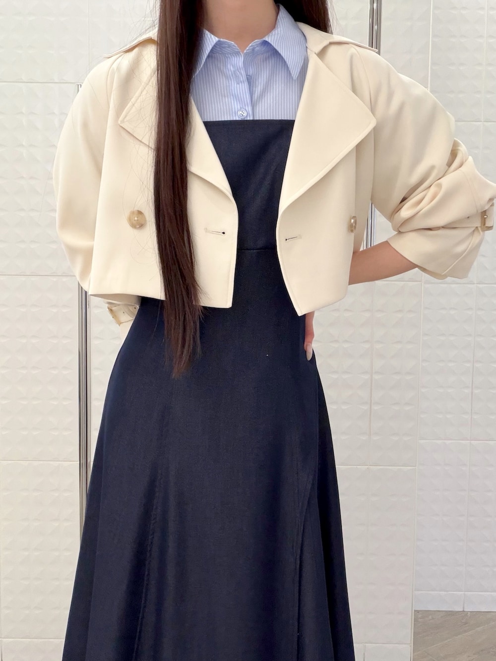 ブルー系のワンピース、ホワイト系のパンプス、ベージュ系のハンドバッグを着用したレディースの春コーディネートの5枚目の写真