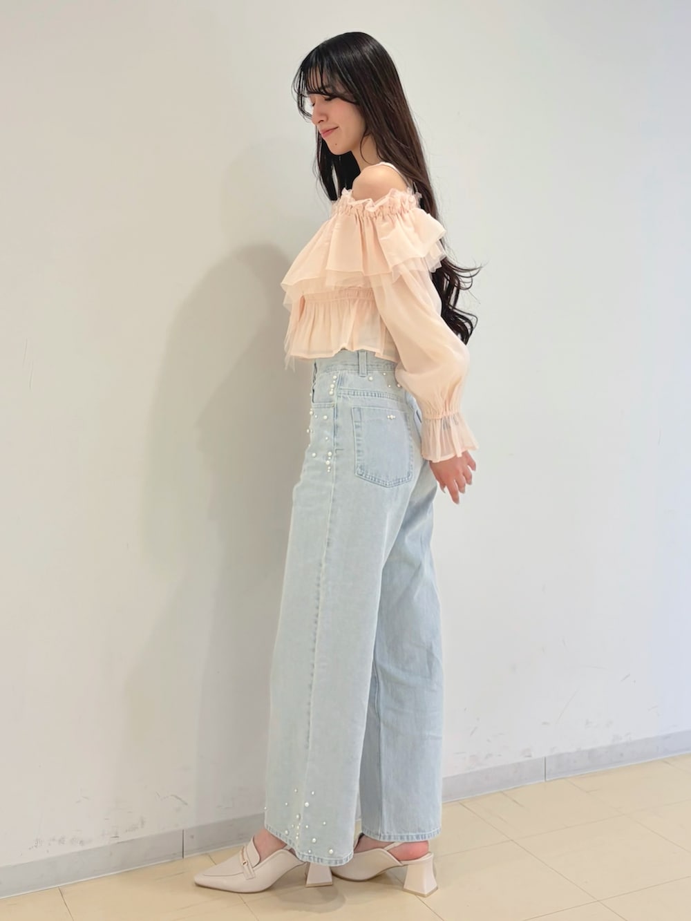 ピンク系のシャツ/ブラウス、ブルー系のデニムパンツ、ブラウン系のハンドバッグを着用したレディースの春コーディネートの2枚目の写真