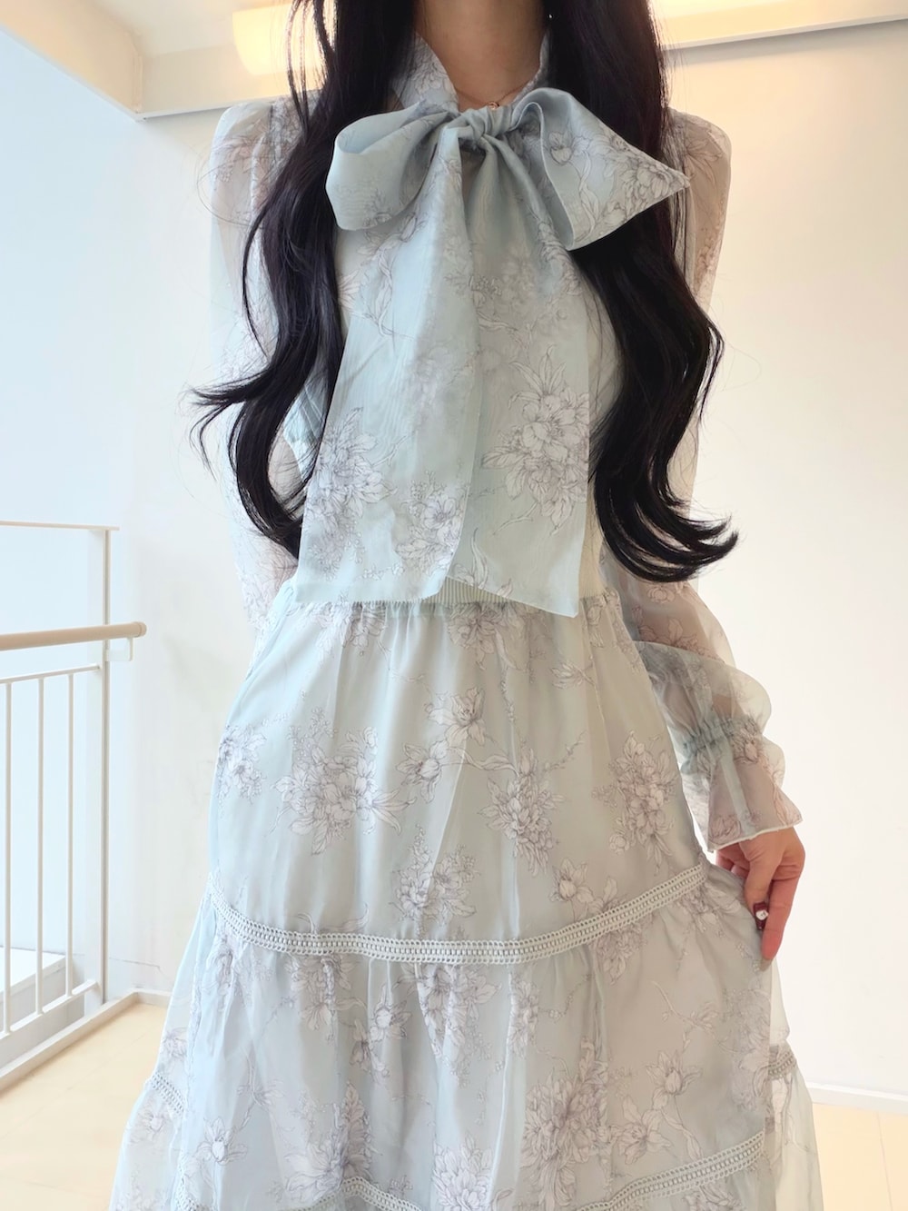 グリーン系のワンピース、ホワイト系のショルダーバッグ、ブラウン系のパンプスを着用したレディースの冬コーディネートの5枚目の写真