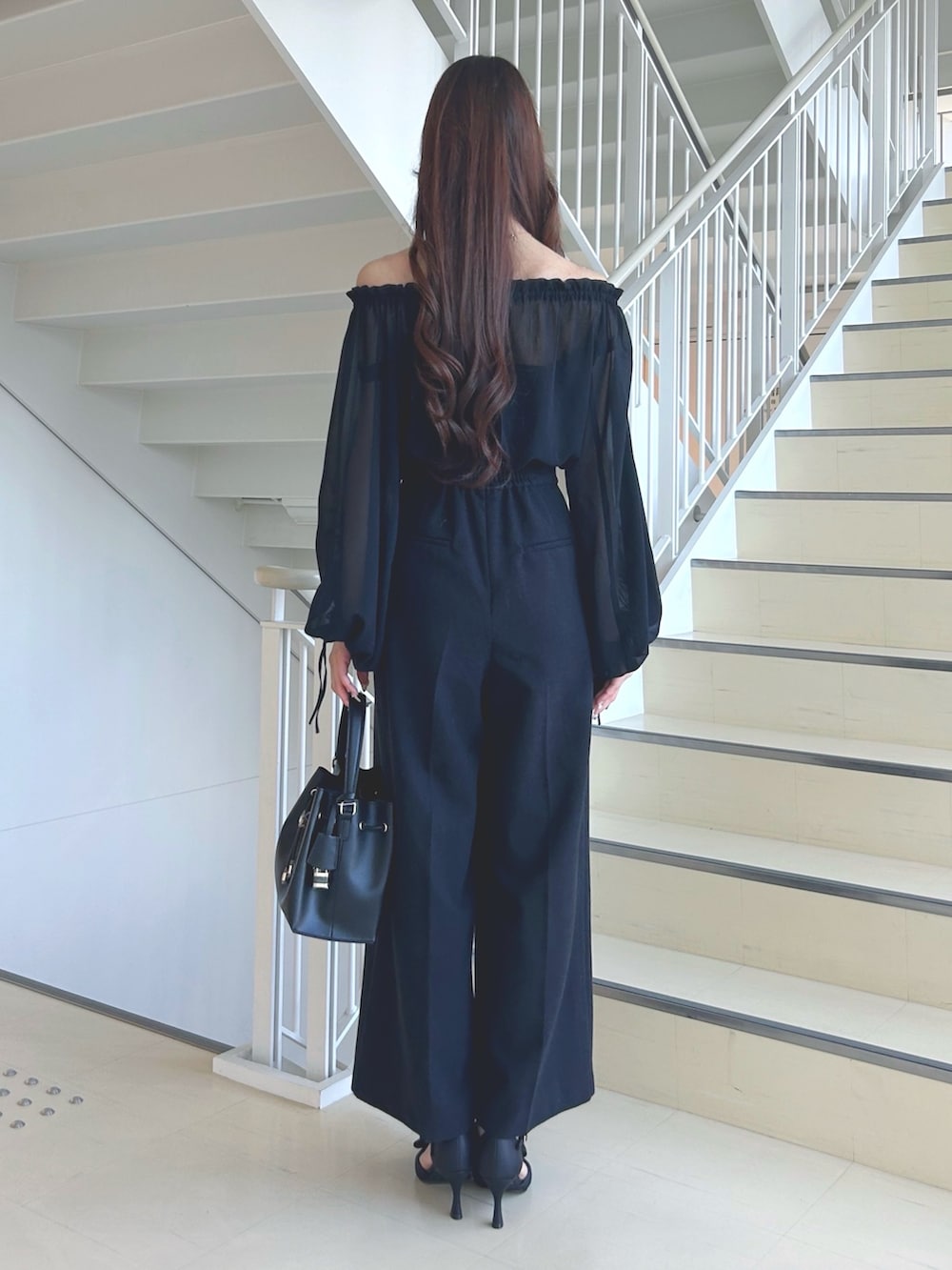 ブラック系のワンピース、ブラック系のショルダーバッグ、ブラック系のパンプスを着用したレディースの秋コーディネートの4枚目の写真