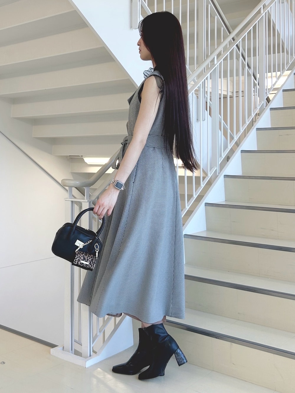 ブラック系のブーツ、ブラック系のハンドバッグ、ブラック系のニット/セーターを着用したレディースの秋コーディネートの2枚目の写真