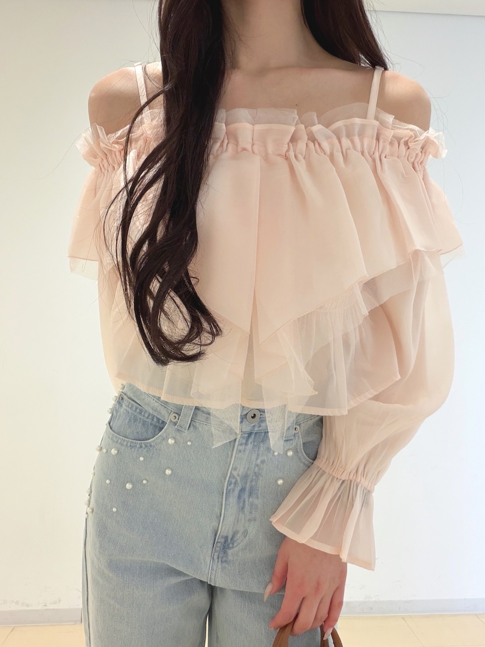 ピンク系のシャツ/ブラウス、ブルー系のデニムパンツ、ブラウン系のハンドバッグを着用したレディースの春コーディネートの7枚目の写真