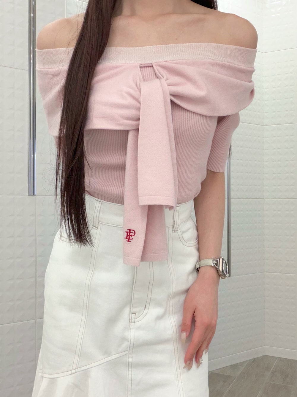 ホワイト系のスカート、ブラウン系のハンドバッグ、ブラウン系のパンプスを着用したレディースの春コーディネートの4枚目の写真