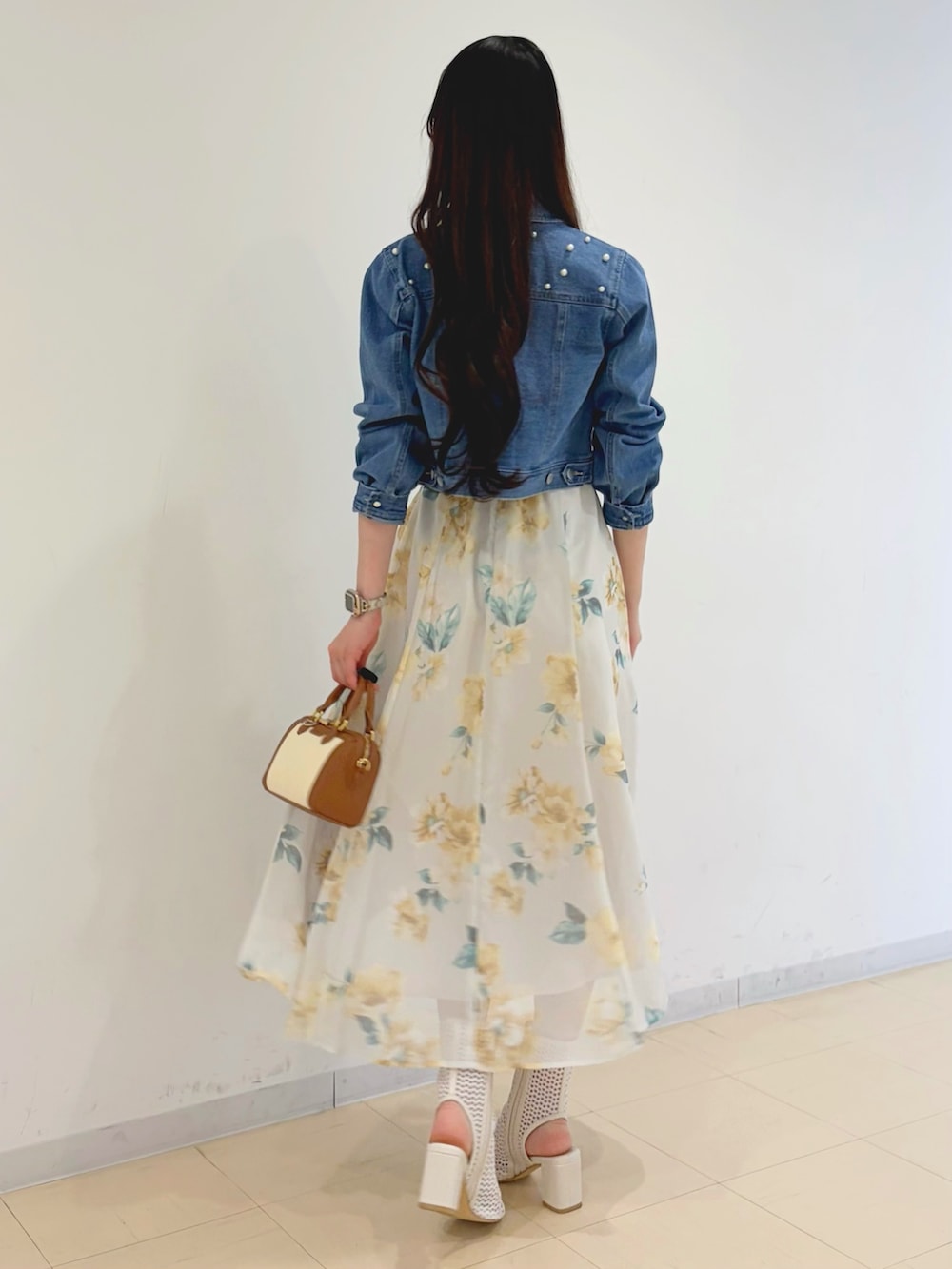 グリーン系のワンピース、ブルー系のデニムジャケット、ブラウン系のハンドバッグを着用したレディースの春コーディネートの5枚目の写真