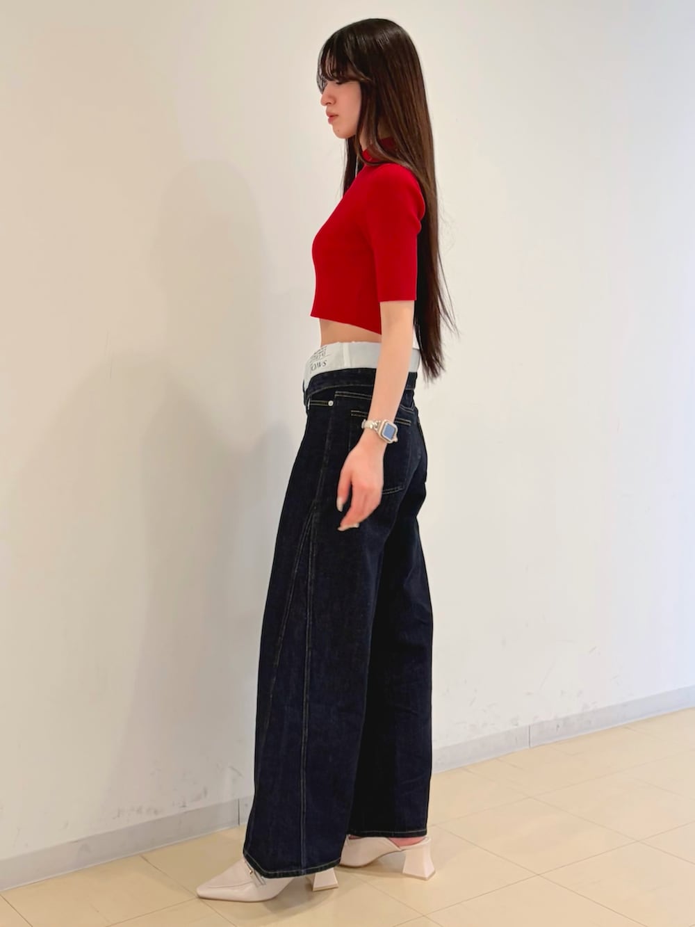 ブルー系のその他パンツ、レッド系のニット/セーター、ブラウン系のハンドバッグを着用したレディースの春コーディネートの4枚目の写真