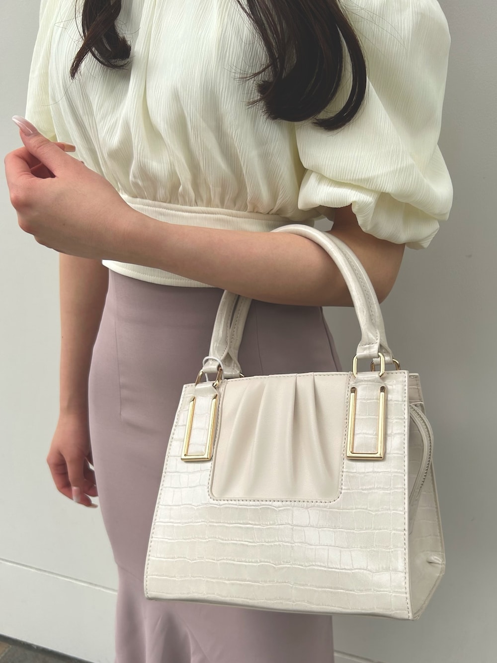 ホワイト系のシャツ/ブラウス、ベージュ系のスカート、ホワイト系のハンドバッグを着用したレディースの夏コーディネートの4枚目の写真