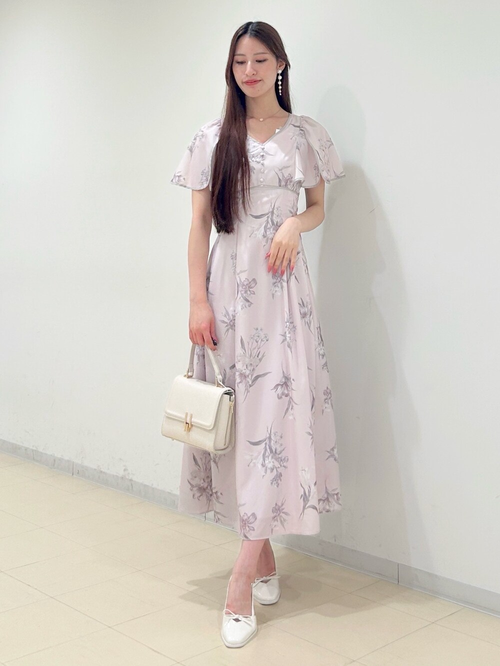 ピンク系のワンピース、ホワイト系のハンドバッグ、ホワイト系のパンプスを着用したレディースの夏コーディネートの3枚目の写真