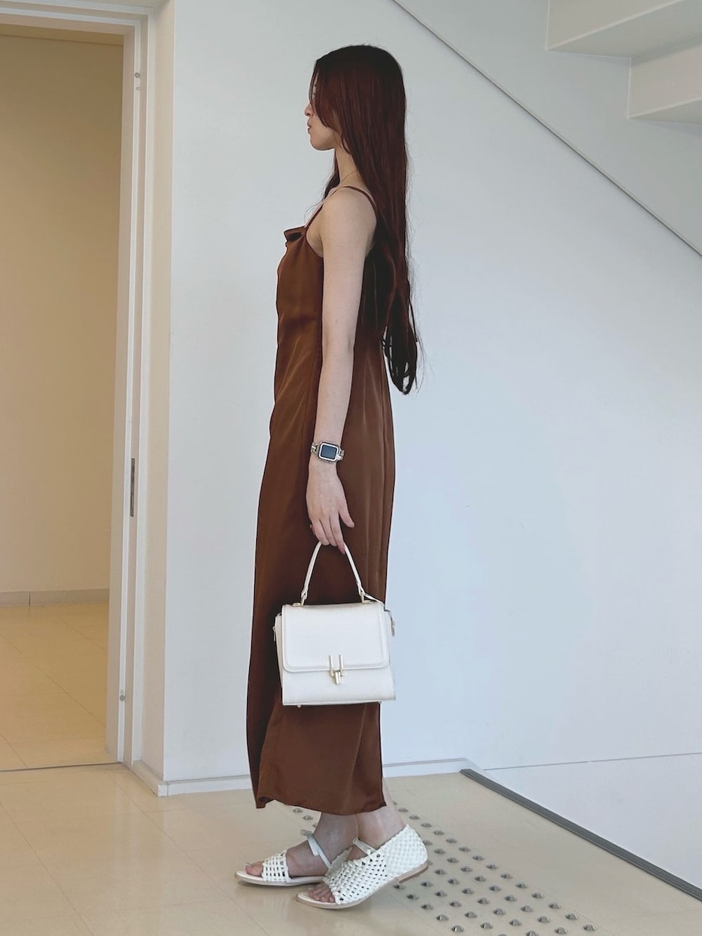 ブラウン系のワンピース、ホワイト系のハンドバッグ、ホワイト系のチューブトップを着用したレディースの夏コーディネートの2枚目の写真