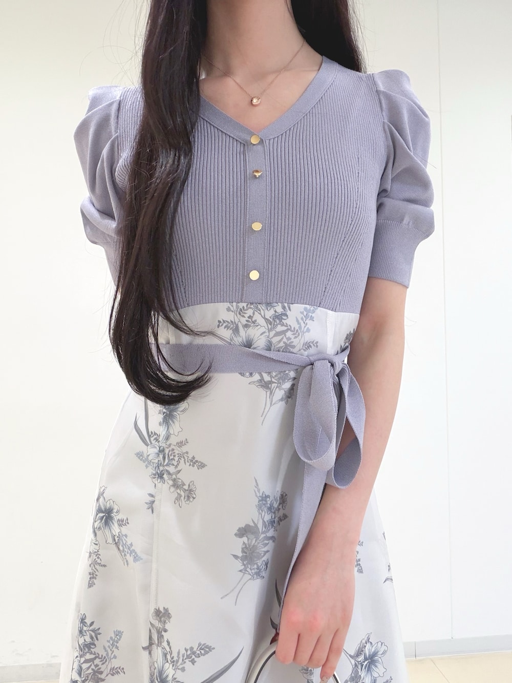 パープル系のワンピース、ホワイト系のショルダーバッグ、ブラウン系のパンプスを着用したレディースの冬コーディネートの4枚目の写真