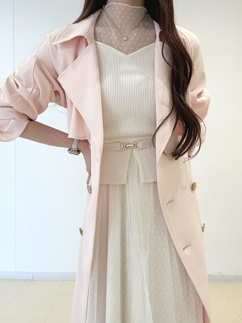 ホワイト系のワンピース、ピンク系のトレンチコート、ゴールド系のショルダーバッグを着用したレディースの冬コーディネートの4枚目の写真