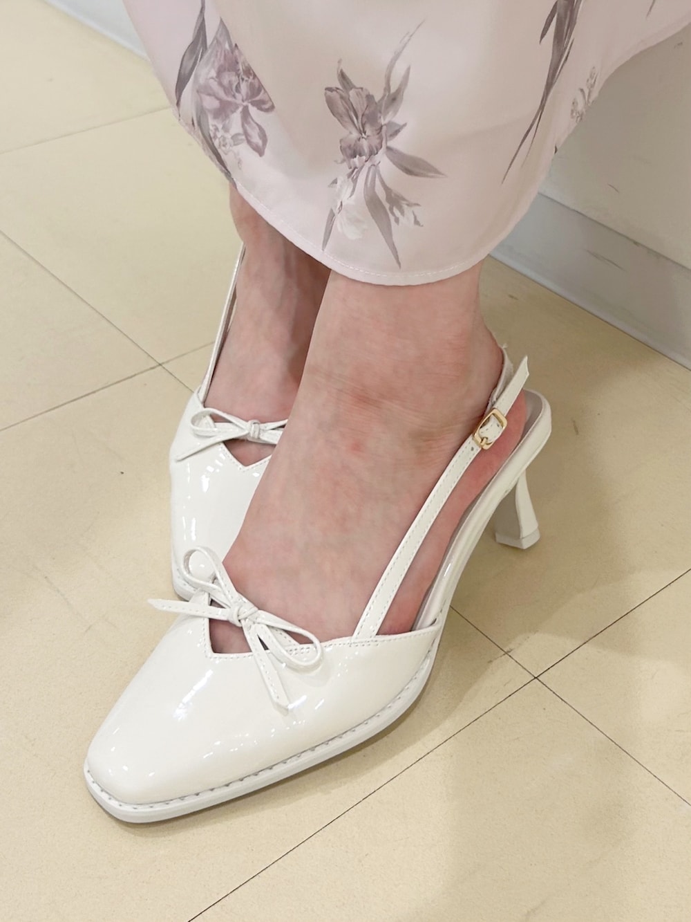 ピンク系のワンピース、ホワイト系のパンプス、ホワイト系のハンドバッグを着用したレディースの夏コーディネートの8枚目の写真