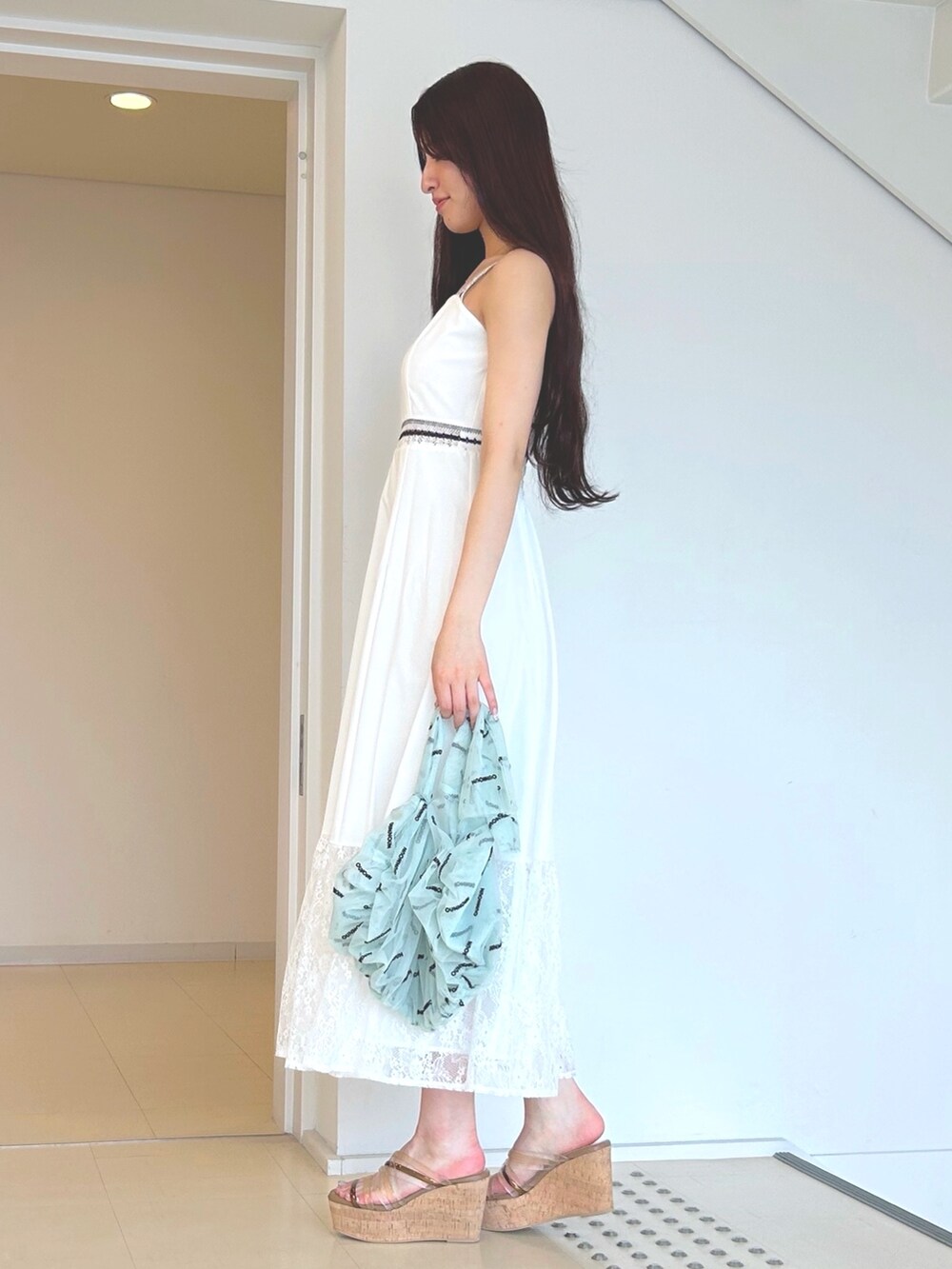 ホワイト系のワンピース、ブラウン系のサンダル、グリーン系のハンドバッグを着用したレディースの夏コーディネートの2枚目の写真