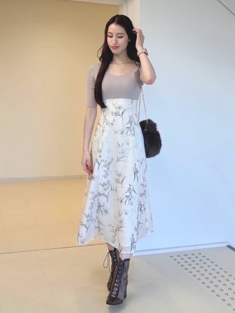 ベージュ系のワンピース、ホワイト系のカーディガン/ボレロ、ブラウン系のハンドバッグを着用したレディースの秋コーディネートの3枚目の写真