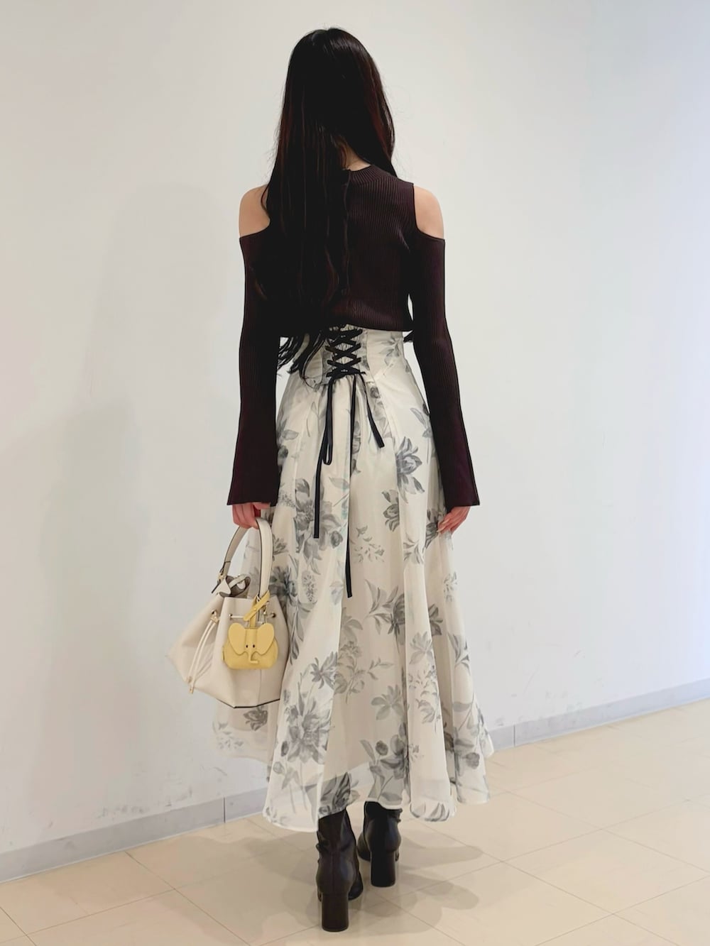 ホワイト系のスカート、ブラウン系のブーツ、ホワイト系のショルダーバッグを着用したレディースの冬コーディネートの3枚目の写真