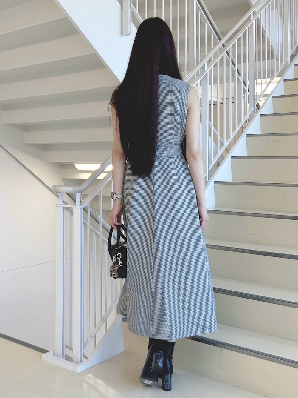 ブラック系のブーツ、ブラック系のハンドバッグ、ブラック系のニット/セーターを着用したレディースの秋コーディネートの4枚目の写真