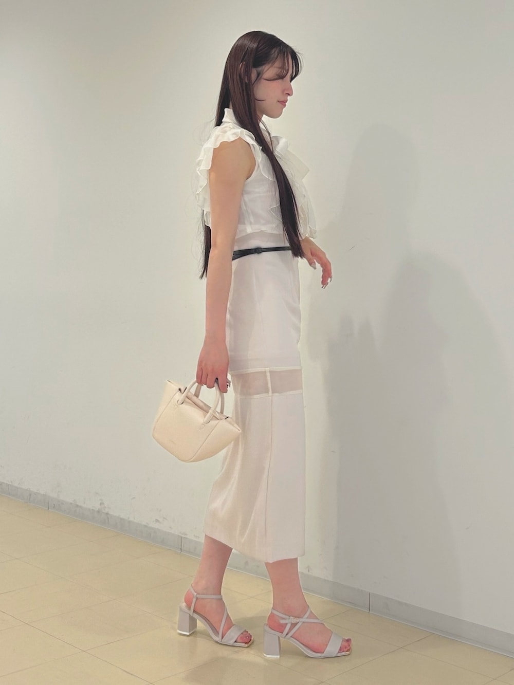 ピンク系のスカート、ベージュ系のサンダル、ホワイト系のシャツ/ブラウスを着用したレディースの春コーディネートの2枚目の写真
