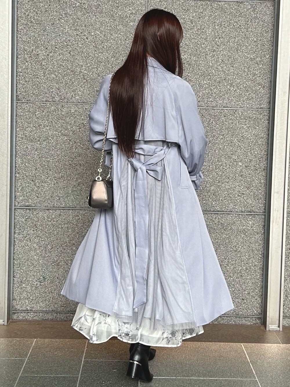 ブラック系のワンピース、ブルー系のトレンチコート、ブラウン系のハンドバッグを着用したレディースの秋コーディネートの5枚目の写真