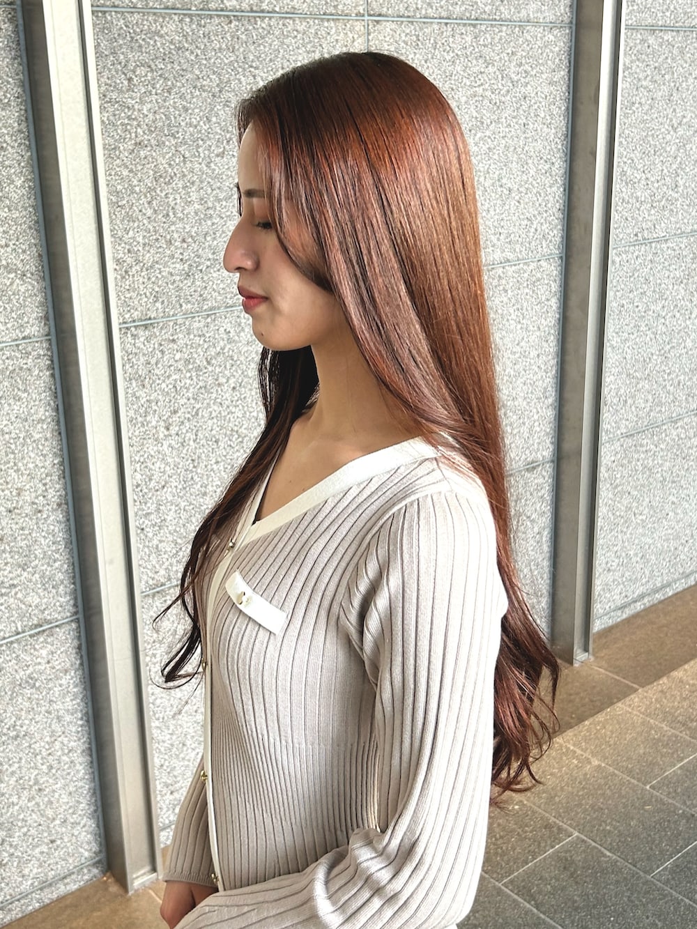 ブラウン系のハンドバッグ、ホワイト系のライダースジャケット、ピンク系のワンピースを着用したレディースの冬コーディネートの5枚目の写真