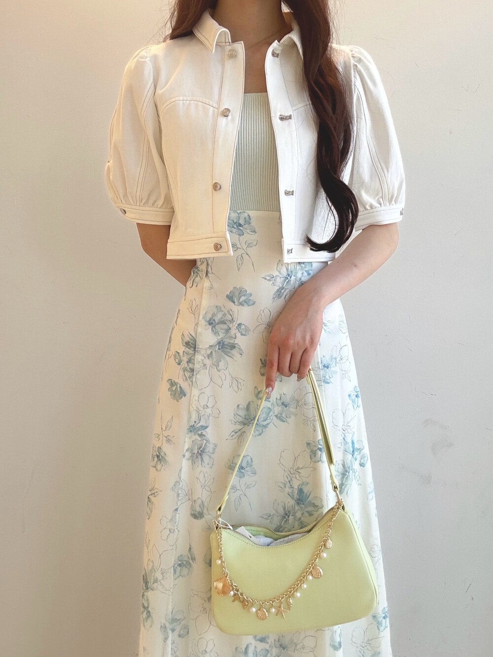 グリーン系のワンピース、グリーン系のハンドバッグ、ホワイト系のサンダルを着用したレディースの夏コーディネートの5枚目の写真