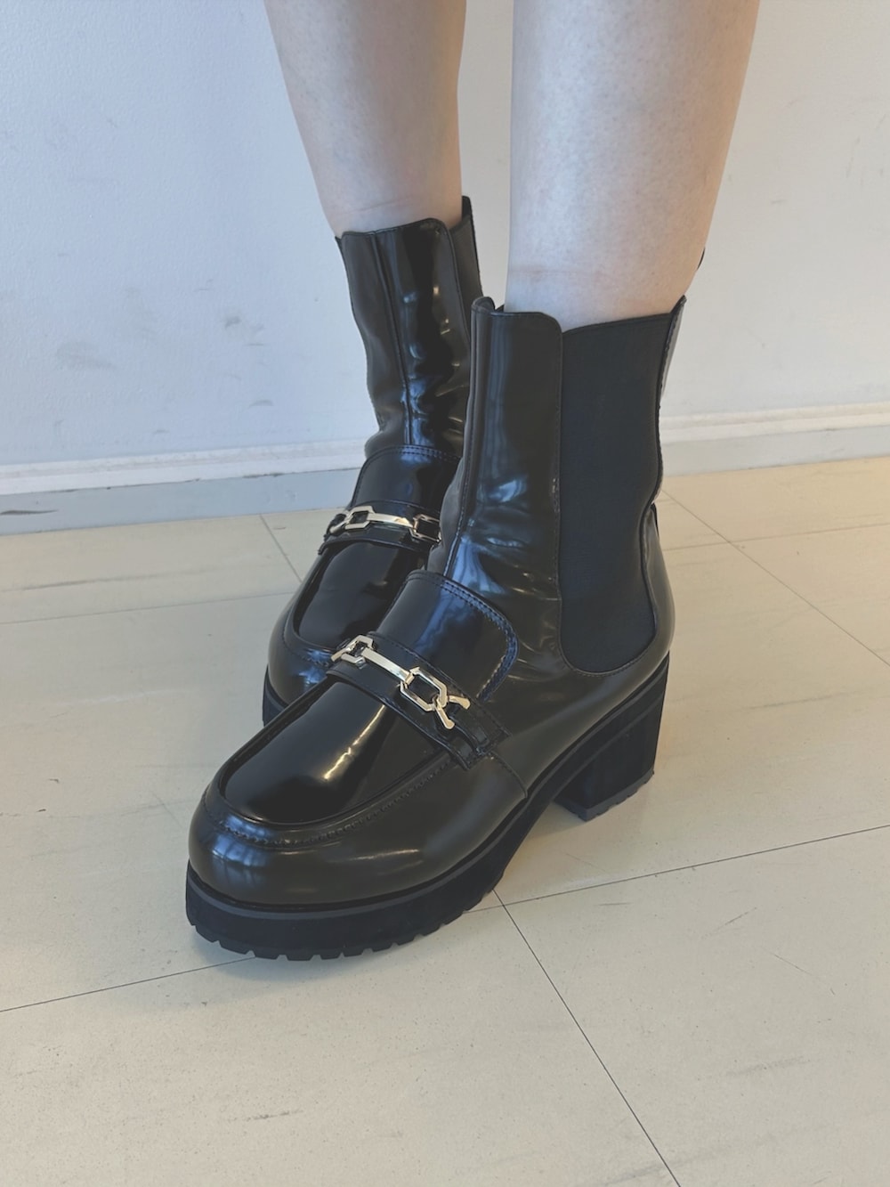 ブラウン系のワンピース、ホワイト系のハンドバッグ、ブラック系のブーツを着用したレディースの秋コーディネートの7枚目の写真