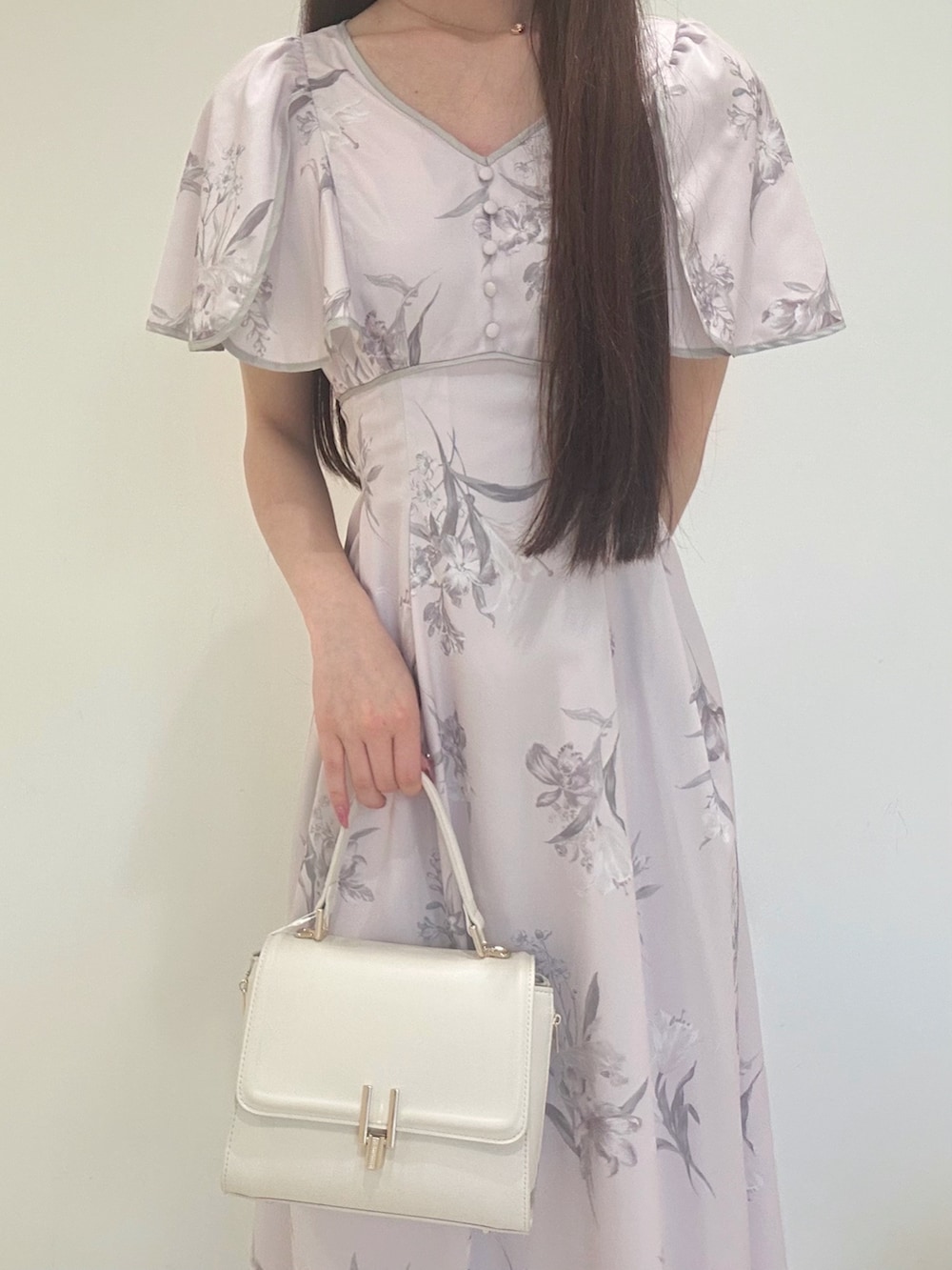 ピンク系のワンピース、ホワイト系のハンドバッグ、ホワイト系のパンプスを着用したレディースの夏コーディネートの5枚目の写真