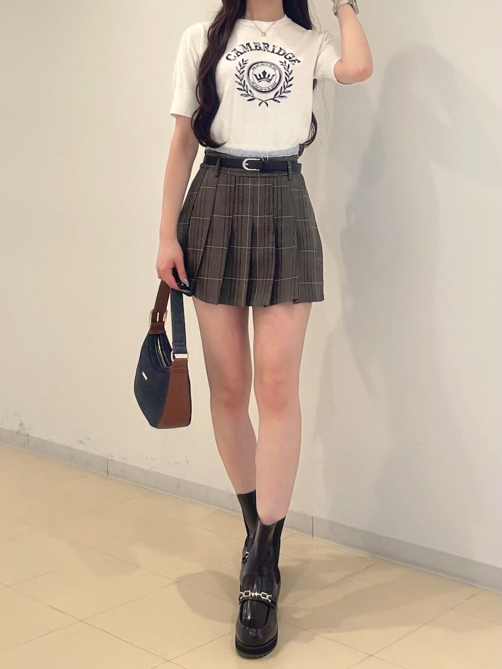 ブラウン系のスカート、ブルー系のショルダーバッグ、ブラウン系のブーツを着用したレディースの夏コーディネートの7枚目の写真