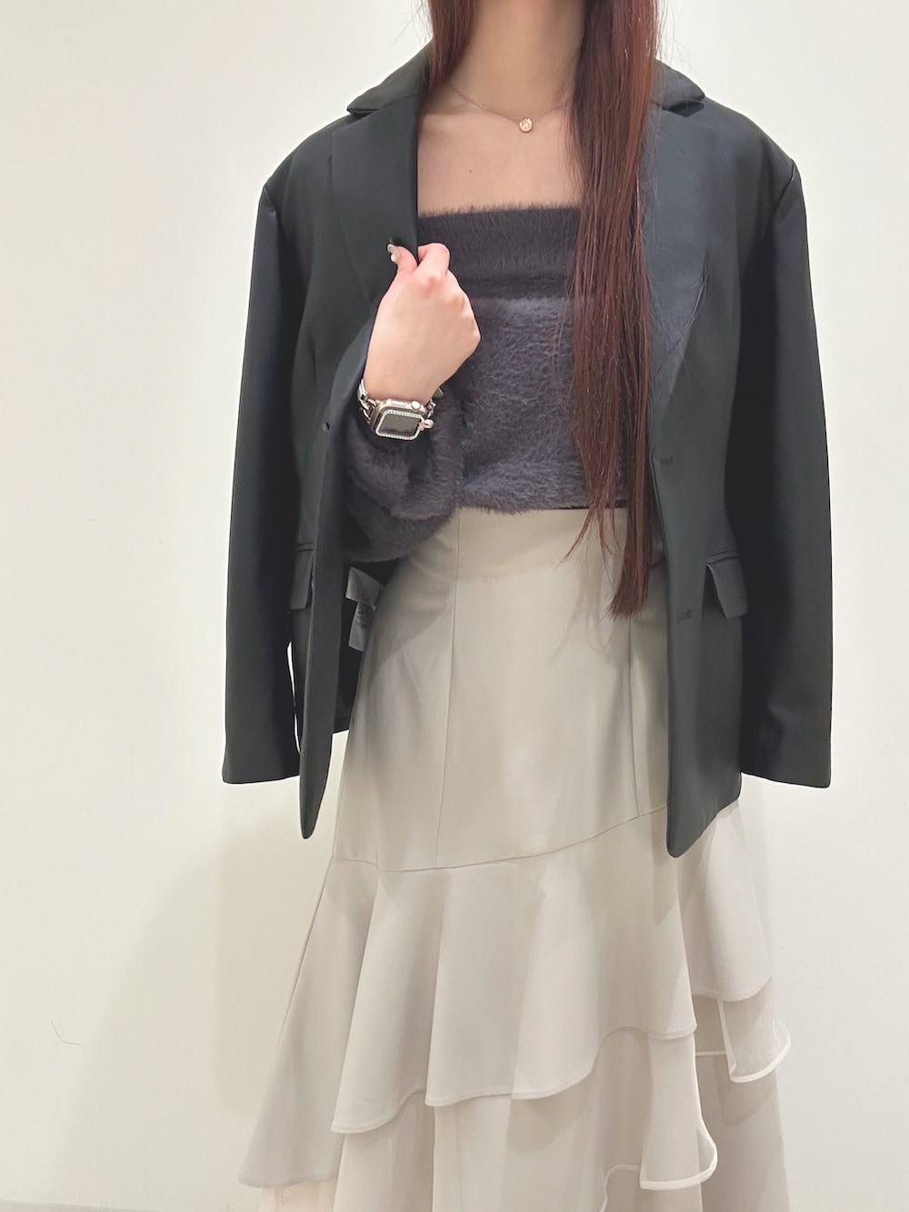 ベージュ系のスカート、グレー系のニット/セーター、ブラック系のハンドバッグを着用したレディースの秋コーディネートの5枚目の写真