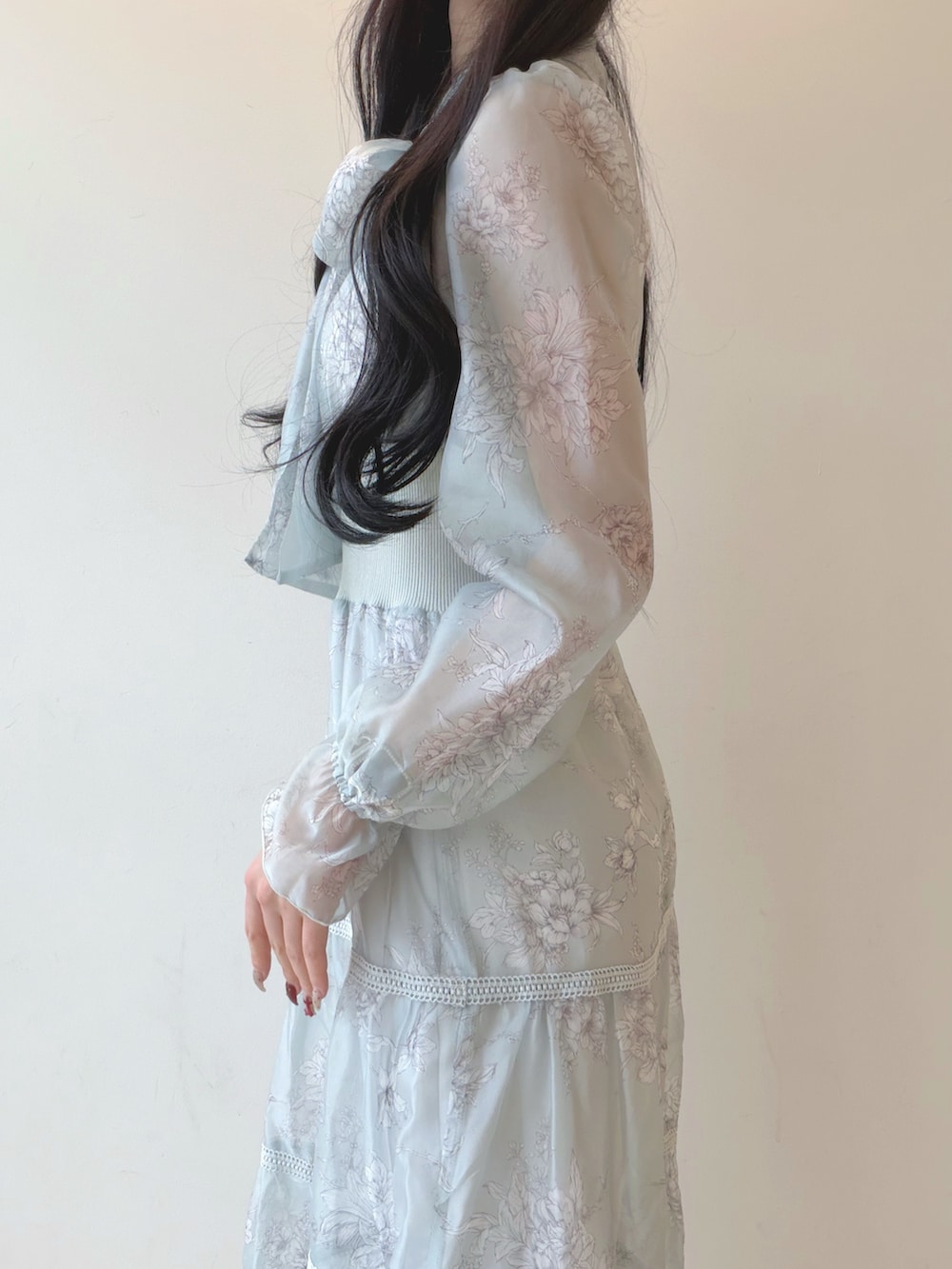 グリーン系のワンピース、ホワイト系のショルダーバッグ、ブラウン系のパンプスを着用したレディースの冬コーディネートの6枚目の写真