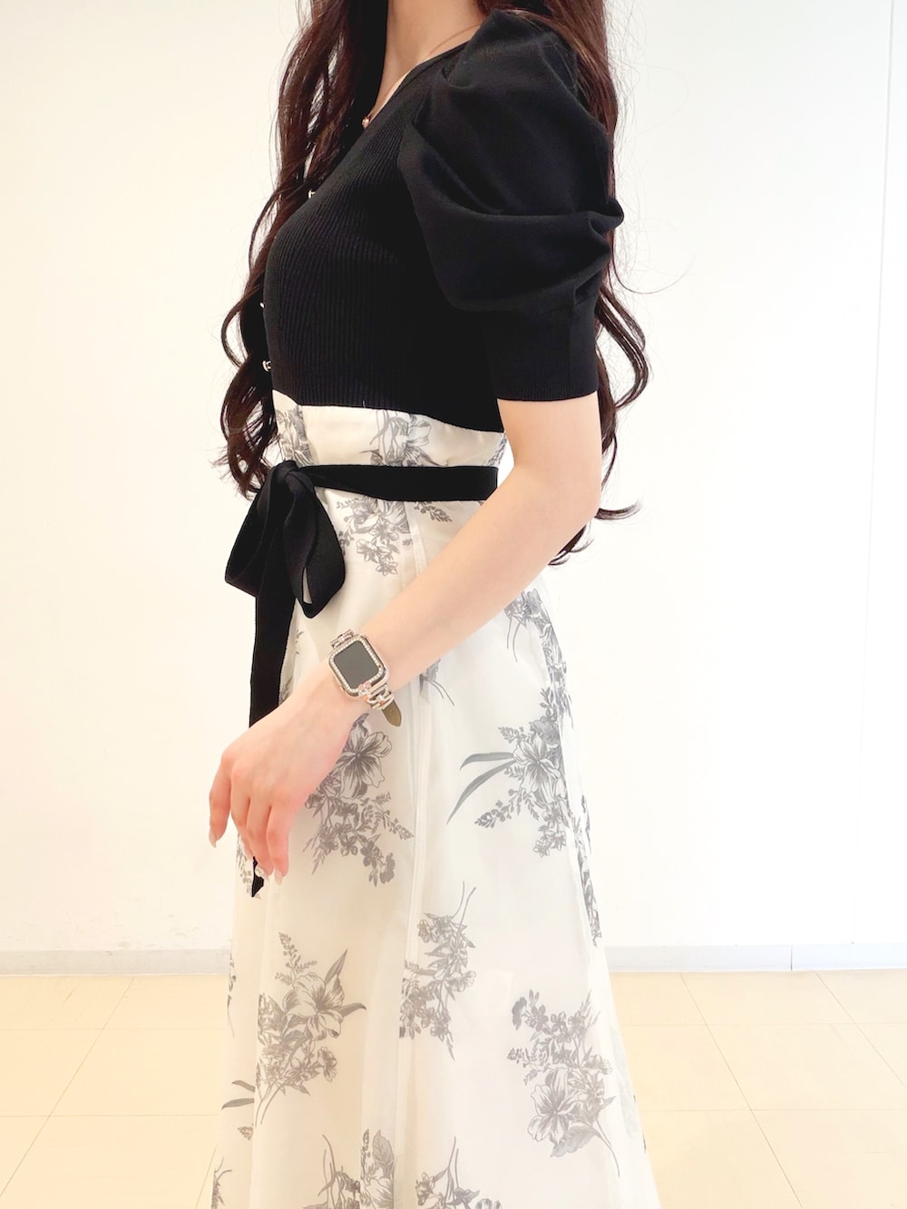 ブラック系のワンピース、ブラウン系のハンドバッグ、ブラウン系のパンプスを着用したレディースの春コーディネートの6枚目の写真