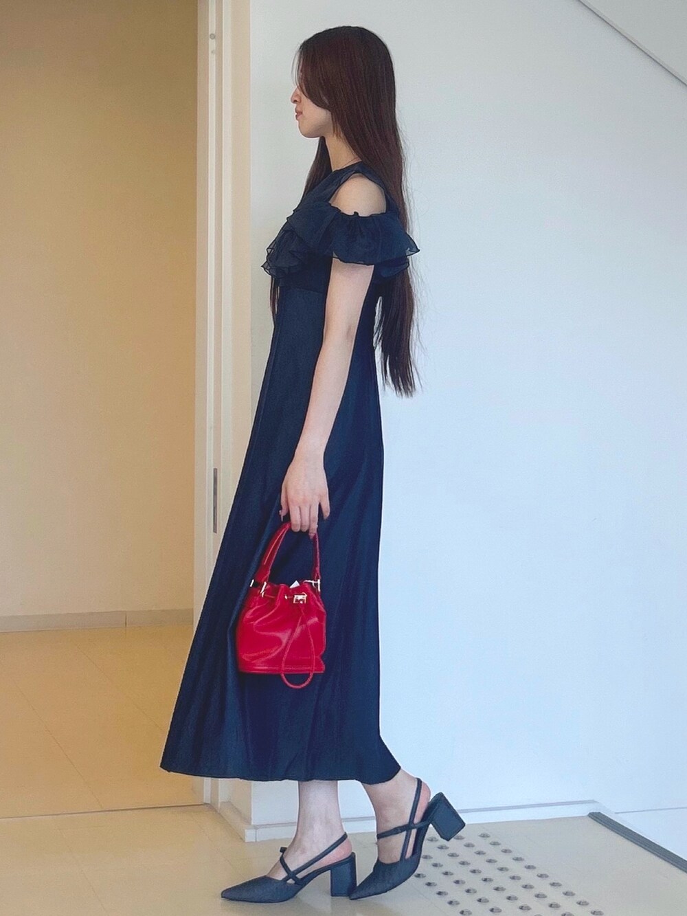 ブルー系のワンピース、レッド系のハンドバッグ、ブルー系のパンプスを着用したレディースの夏コーディネートの2枚目の写真