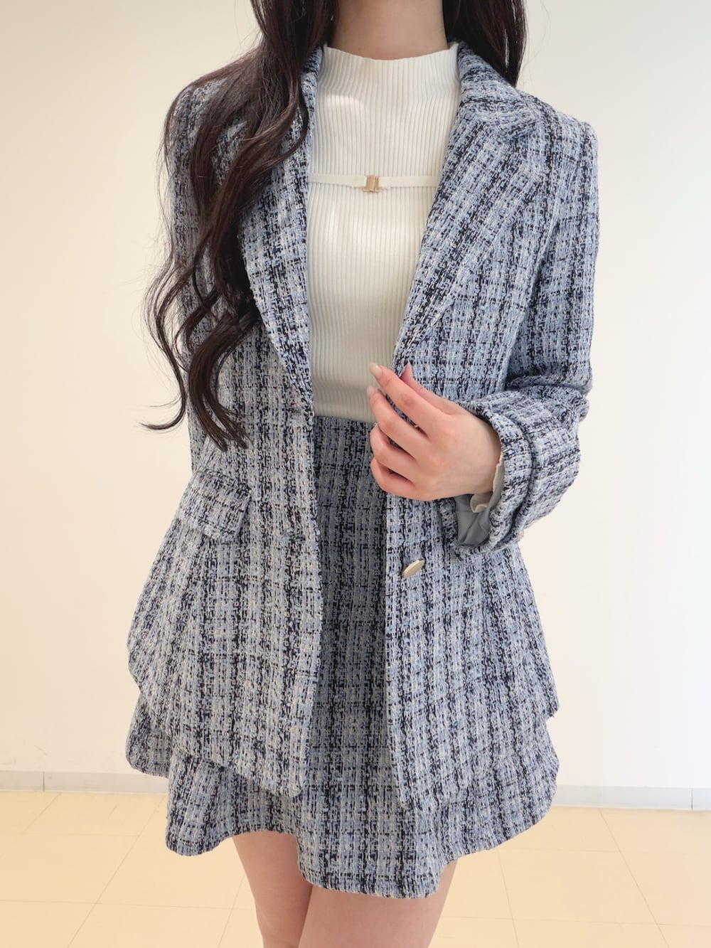 ブルー系のテーラードジャケット、ブルー系のスカート、ホワイト系のニット/セーターを着用したレディースの冬コーディネートの4枚目の写真