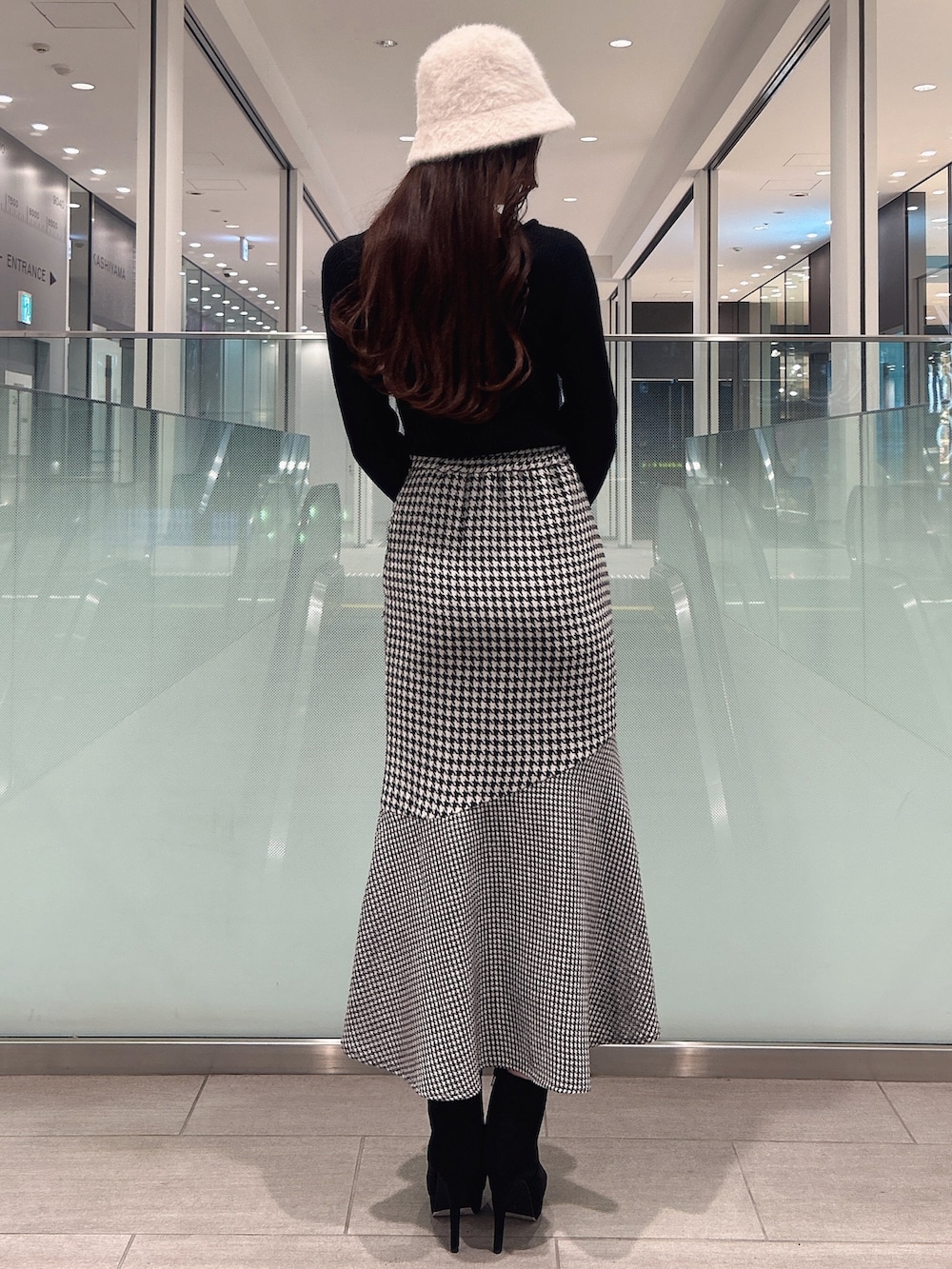 ブラック系のニット/セーター、ブラック系のブーツ、その他のスカートを着用したレディースの冬コーディネートの3枚目の写真