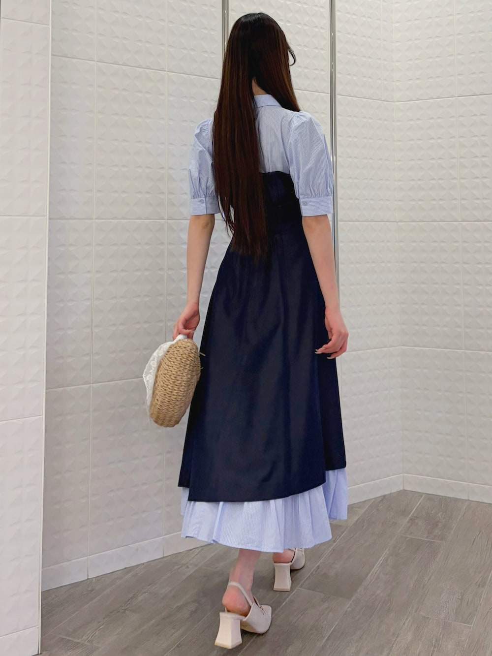 ブルー系のワンピース、ホワイト系のパンプス、ベージュ系のハンドバッグを着用したレディースの春コーディネートの4枚目の写真