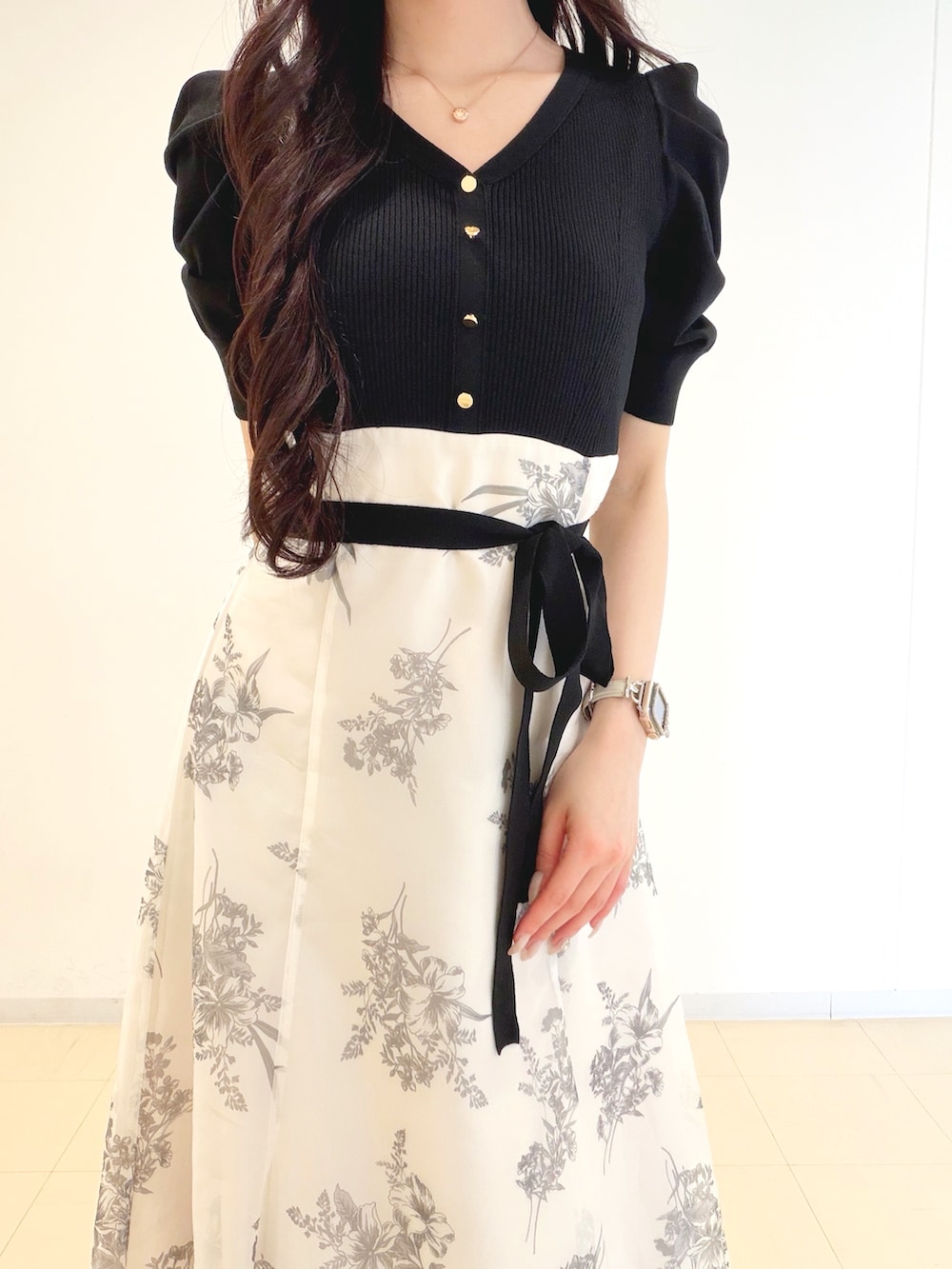 ブラック系のワンピース、ブラウン系のハンドバッグ、ブラウン系のパンプスを着用したレディースの春コーディネートの5枚目の写真