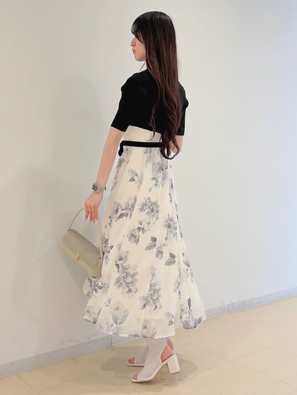 ブラック系のワンピース、パープル系のトレンチコート、ホワイト系のハンドバッグを着用したレディースの春コーディネートの4枚目の写真