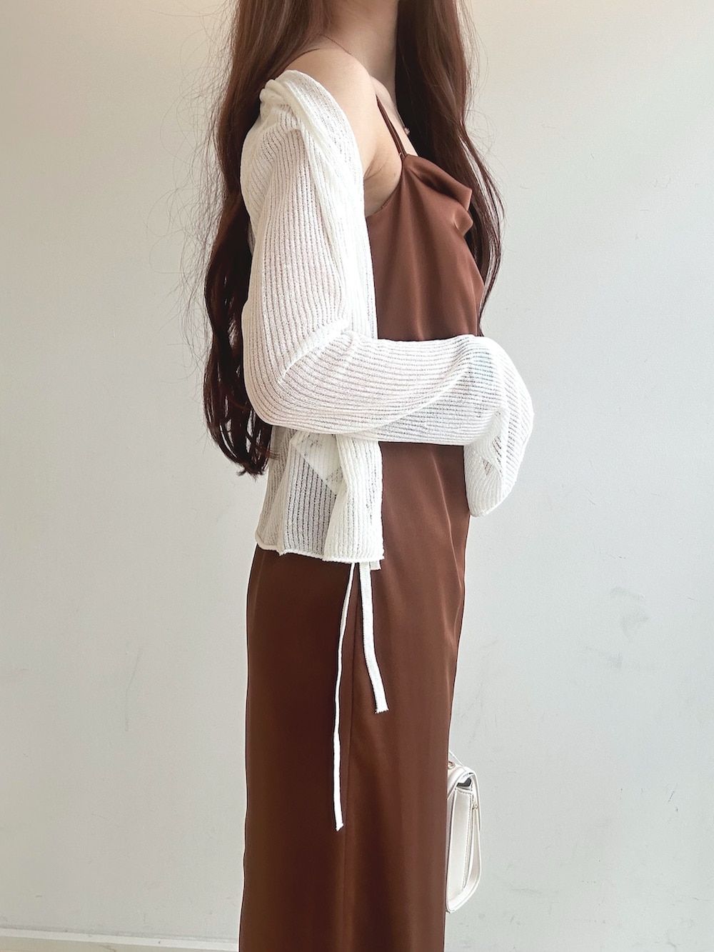 ブラウン系のワンピース、ホワイト系のチューブトップ、ホワイト系のハンドバッグを着用したレディースの夏コーディネートの6枚目の写真