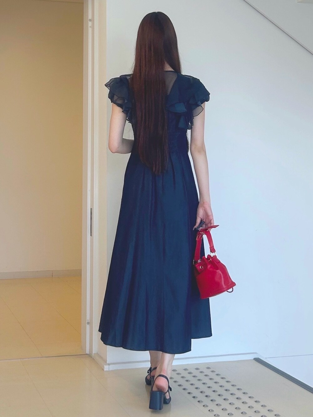 ブルー系のワンピース、レッド系のハンドバッグ、ブルー系のパンプスを着用したレディースの夏コーディネートの4枚目の写真